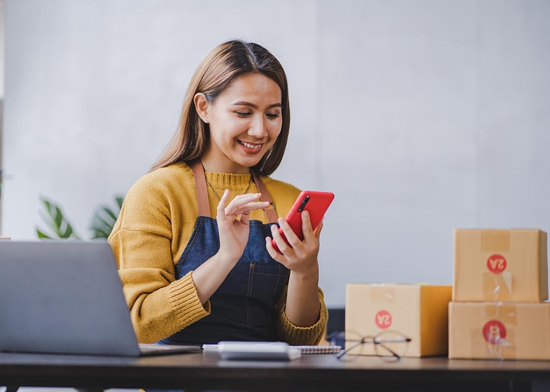 An entrepreneur checking and packing orders from her online marketplace.