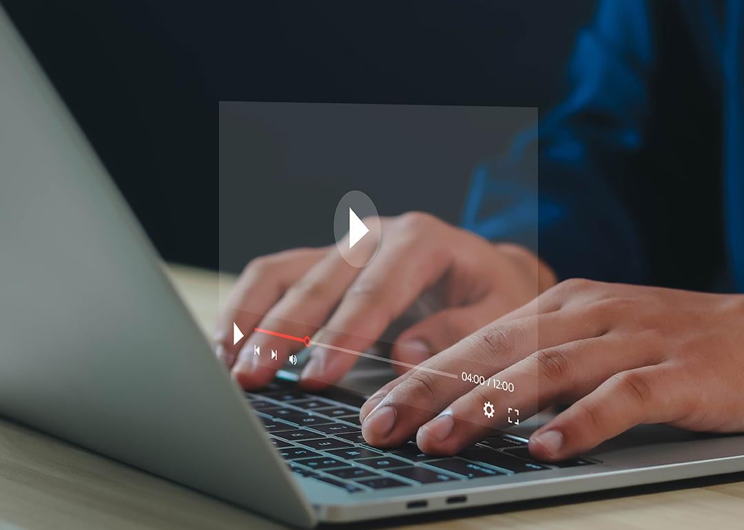 Graphic of a YouTube video screen over a person using a laptop.