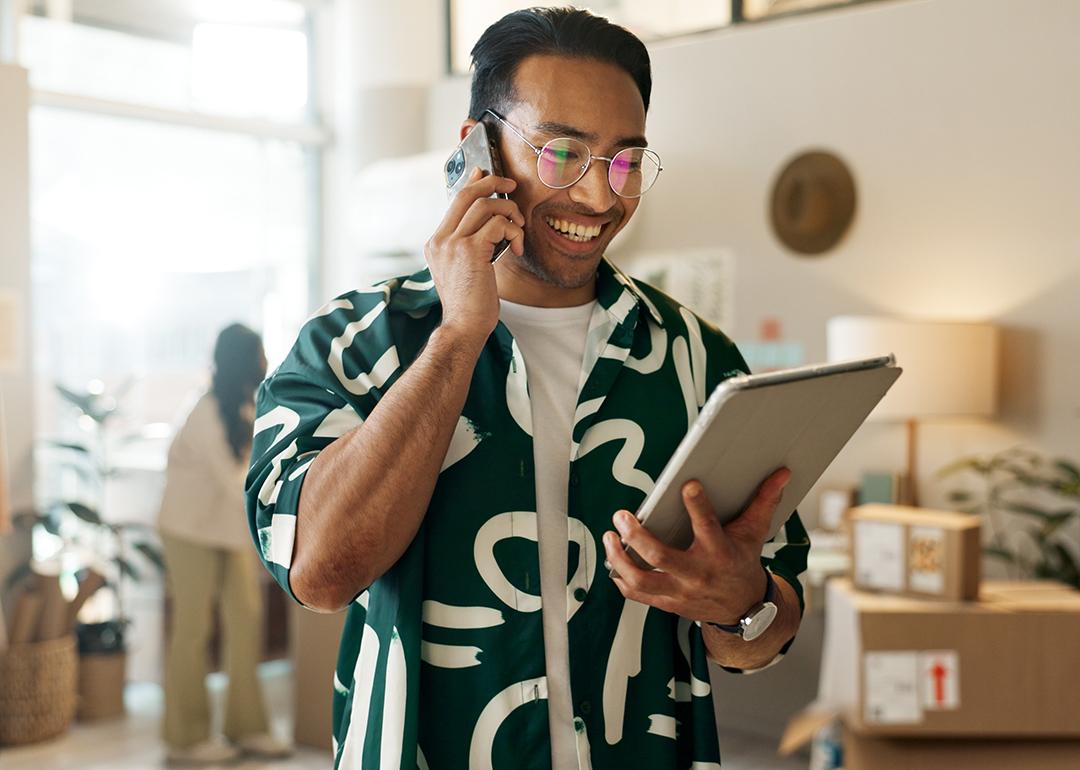 A man on the phone and looking at a tablet for an order.