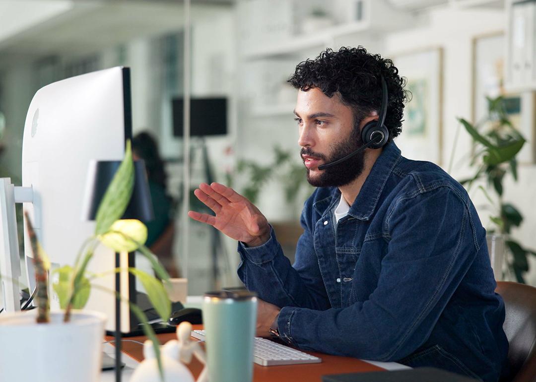 A male customer service representative on call with a client.