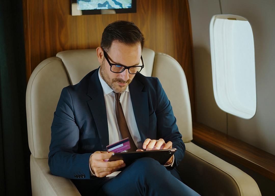 A business executive shopping online while traveling from a private jet's cabin.