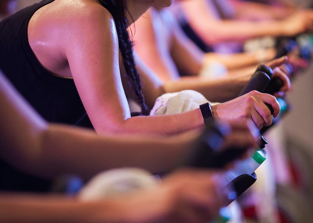 Close up on the intense sweat in the arms of bike spin class students.