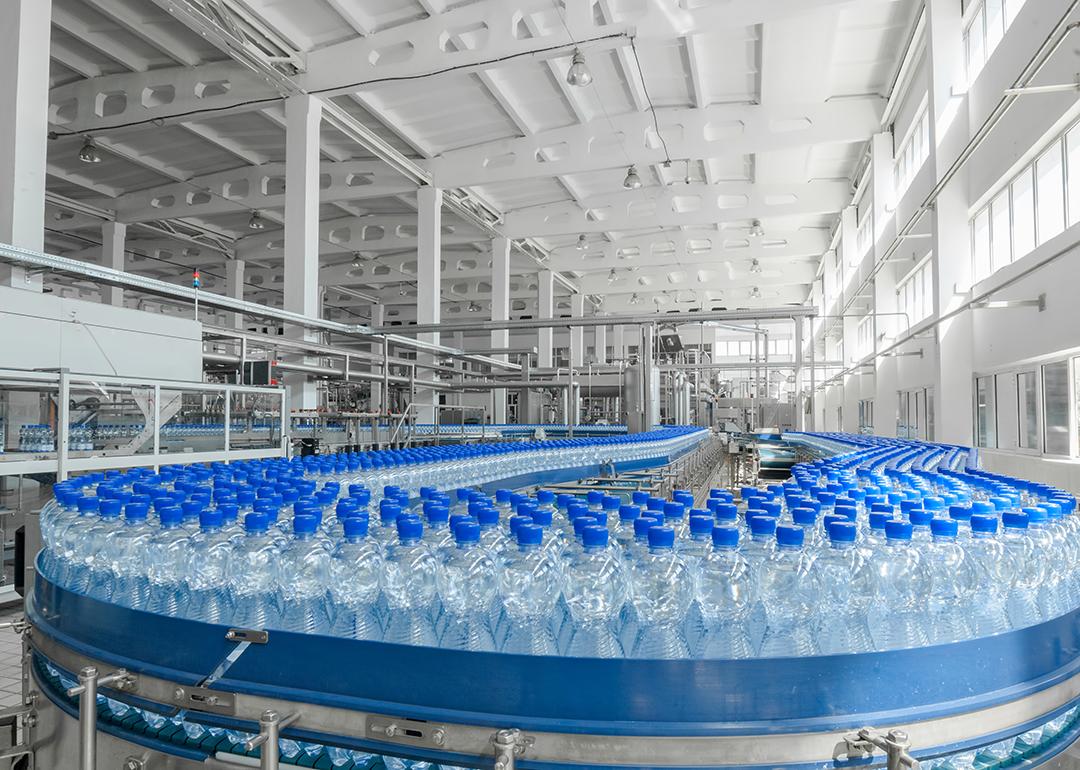 Massive production of plastic bottles on factory's conveyor belt.