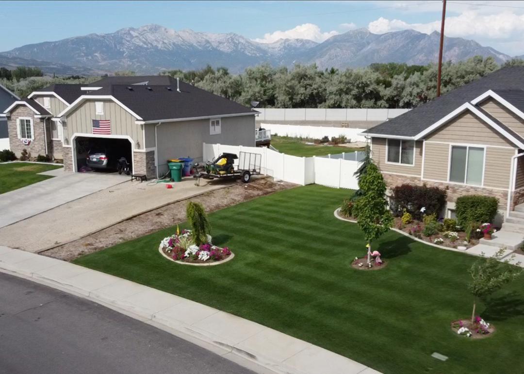Aerial view of Jimmy Lewis’s golf course-like lawn in Utah, with striping patterns in green grass and three small trees in yard.