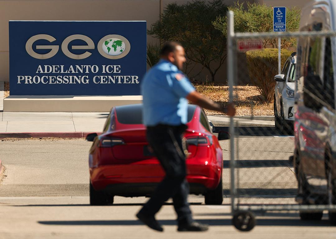 An officer closing a security gate at the GEO Group Adelanto ICE Processing Center in California.