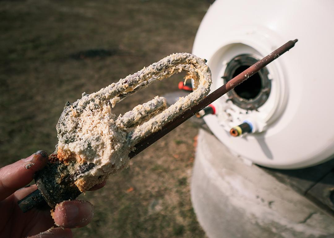A plumber holding a heating element after a long-term use.