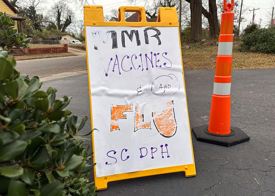 A sign advertising MMR and flu vaccines in a parking lot next to an orange pylon in South Carolina where outbreak response leaders have been trying to encourage the public to get vaccinated during a measles outbreak.