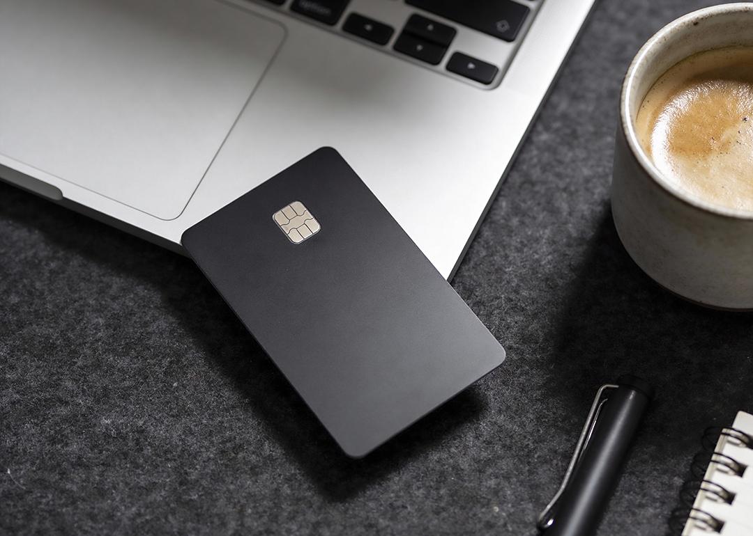 A black credit card on the edge of a laptop.