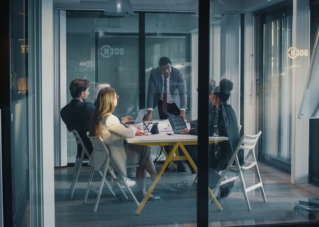 A focused team manager leading a meeting in a conference room.
