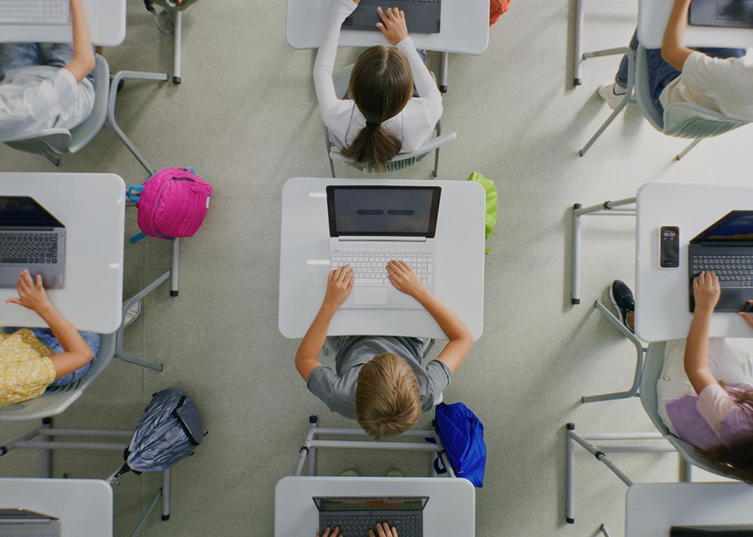 Ceiling view of students working on projects on their laptops inside the classroom.