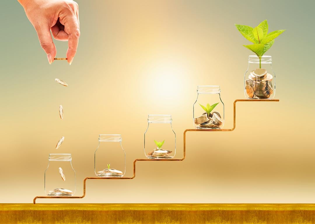 Hand dropping gold coins on jars on a staircase as a concept of financial building.