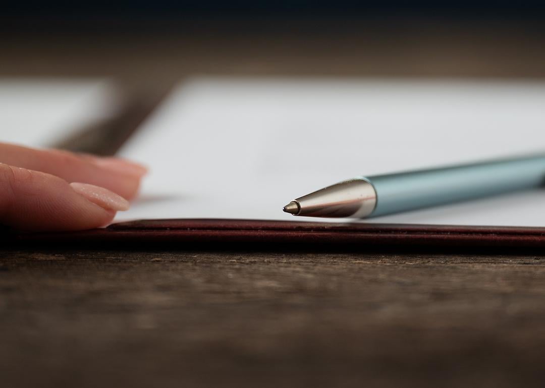 Low angle view of a hand and a pen lying on a document.