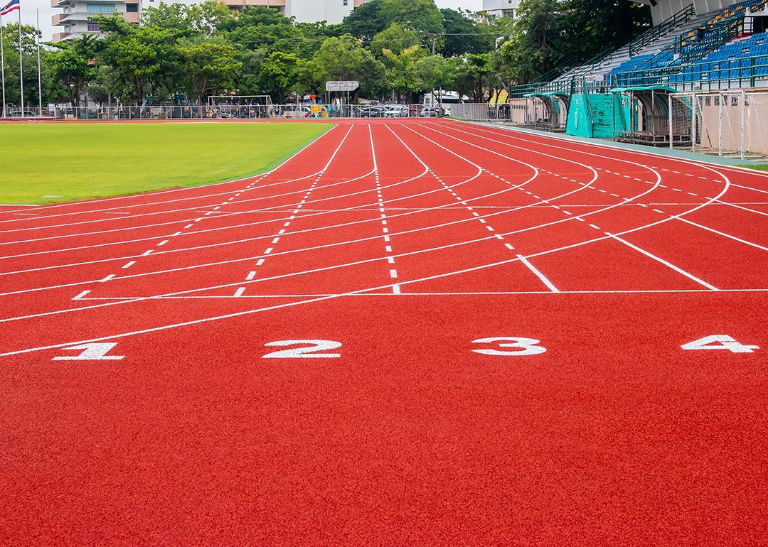 A red running track in an athletic stadium.