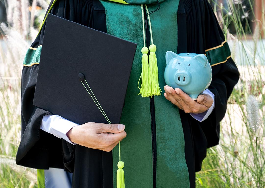 A person wearing a bachelor uniform holding a cap and a piggy bank.