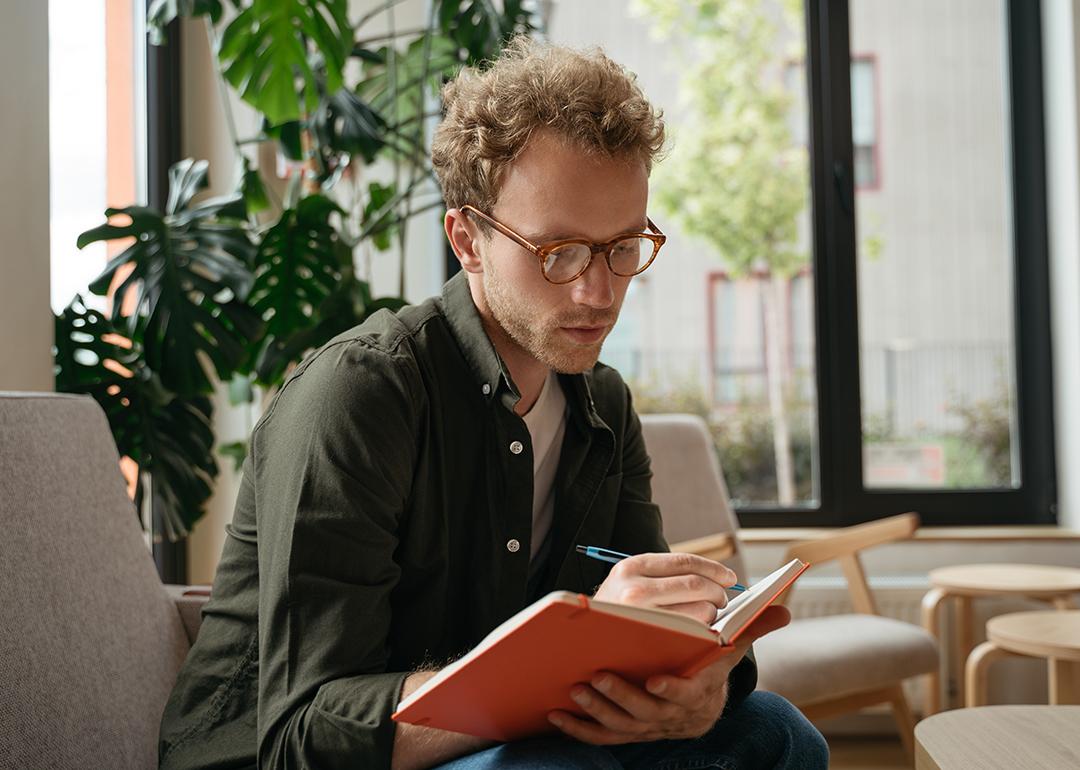 A person taking notes while working in an office.