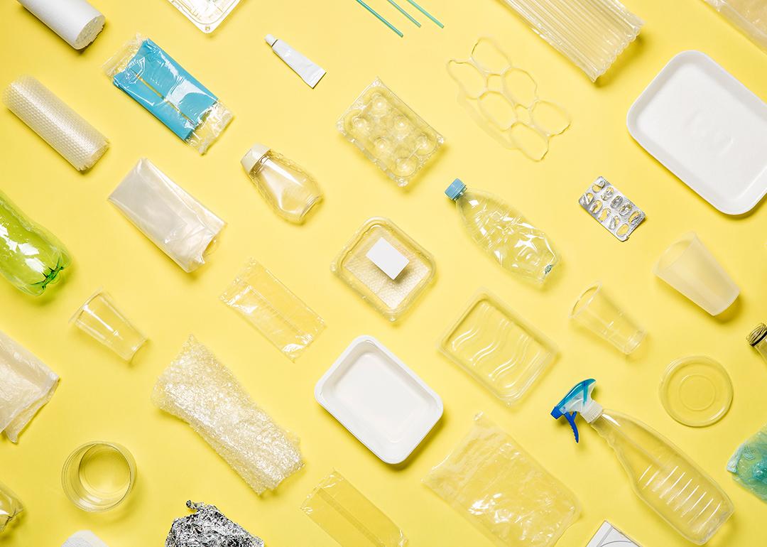 Different types of plastic packaging neatly arranged with a yellow background.
