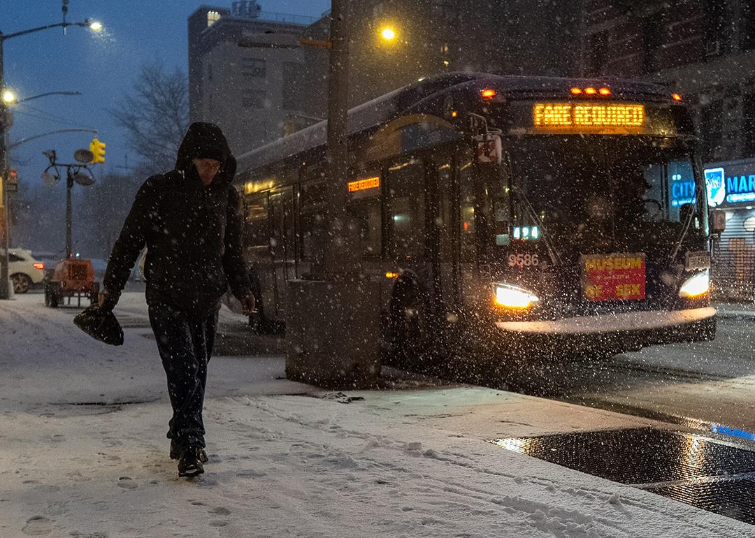 A person walks along the snowy street in New York City, USA.