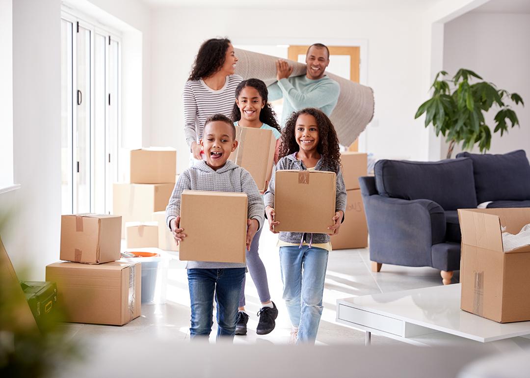 A family of five happily moving boxes into new home.