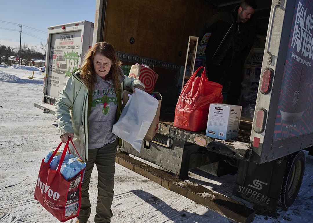 Leah Sheehy, a volunteer with Community Aid Network MN, moves donations from a truck parked in the snow in Minneapolis, Minnesota, on 2 February.