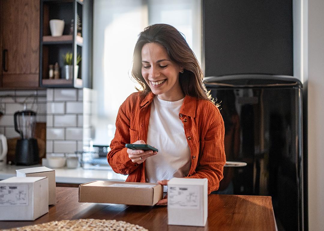 A woman scanning a package's QR code with a phone.