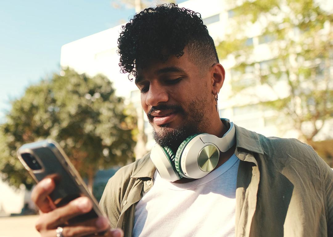 A young man checking phone outdoors.