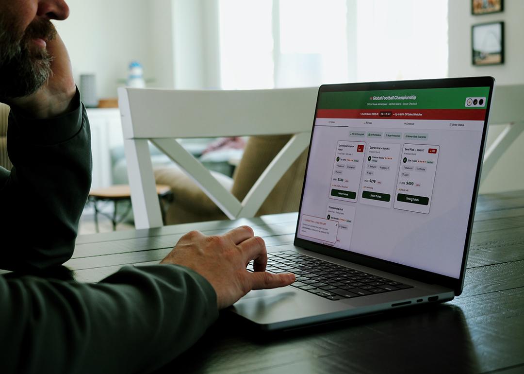 Man at home trying to buy a sports tournament ticket online.