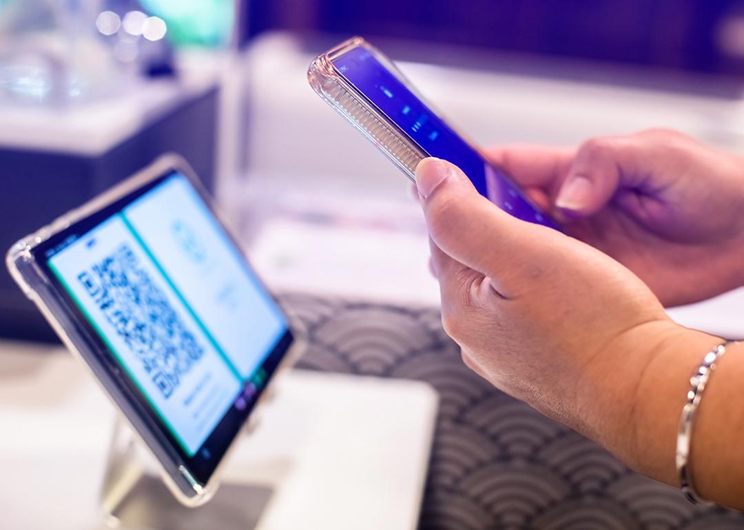 A person using a smart phone to scan a QR code from a smart device for a digital registration.
