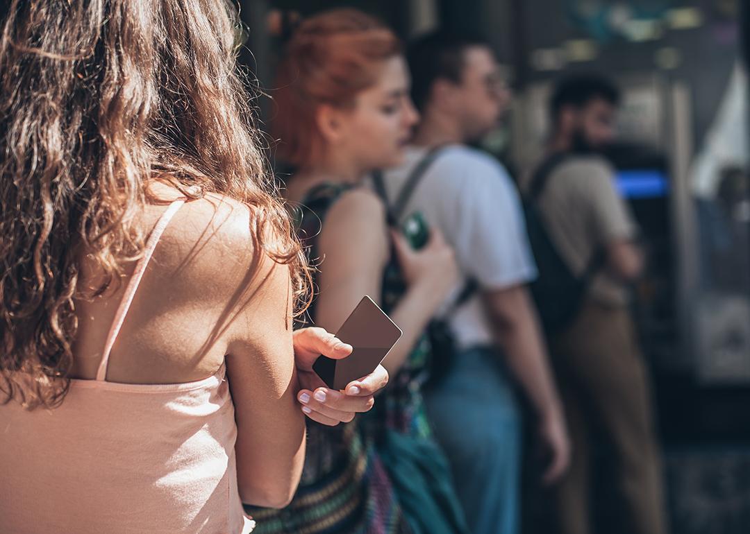 A queue of people waiting to withdraw money from an ATM. 