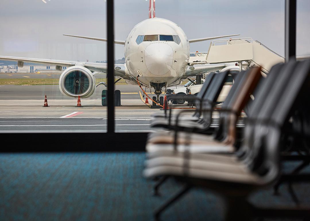 A view of a plane being refueled from the departure area of an airport.