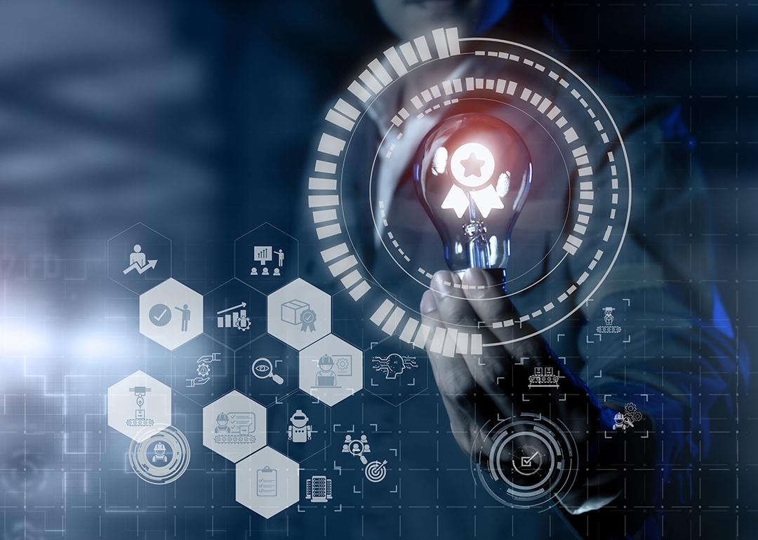 Concept of AI and quality management software graphics around a person holding a lightbulb.