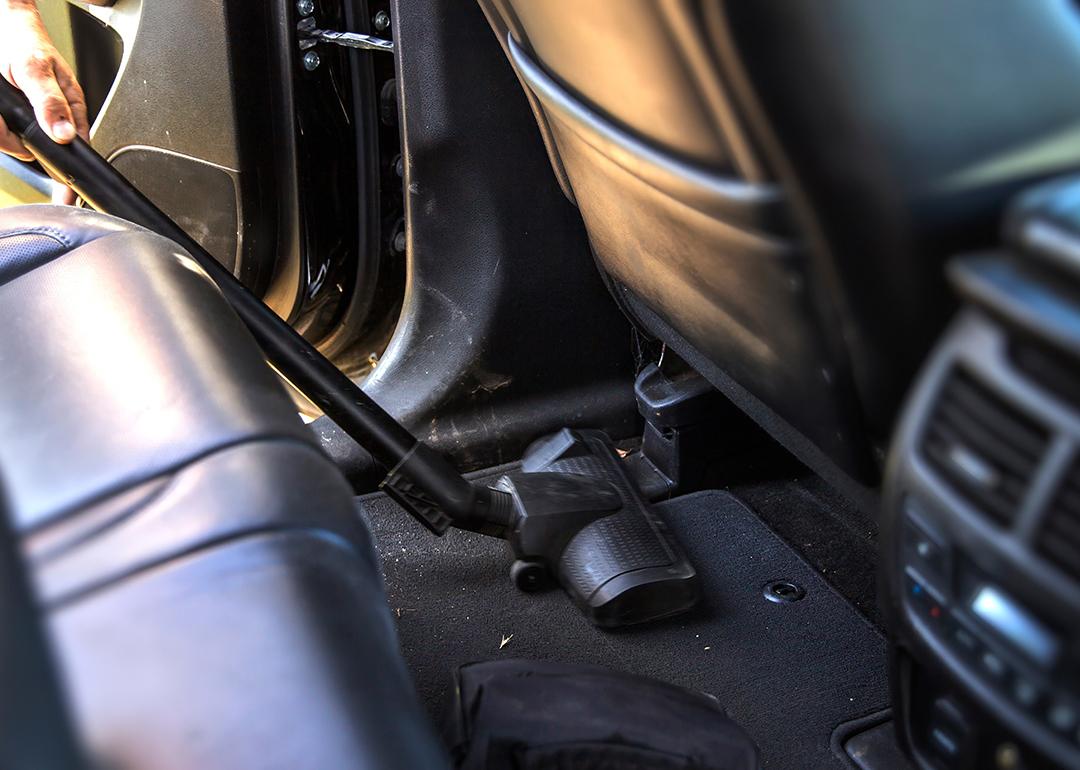 A vacuum cleans the interior of a car.