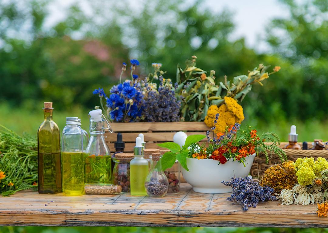 Various medicinal herbs and natural tinctures in a wooden table.