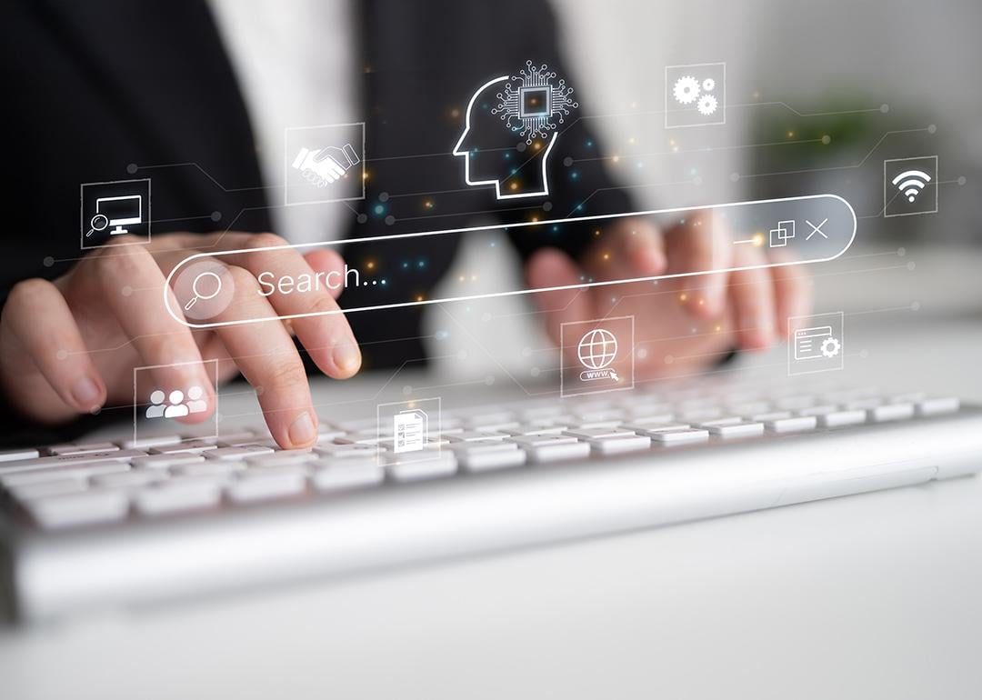 Generative search engine graphics illustrated over a person typing on a keyboard.