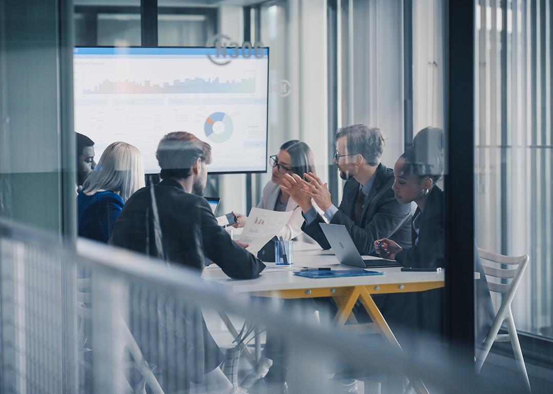 A business team inside a conference room discussing reports.