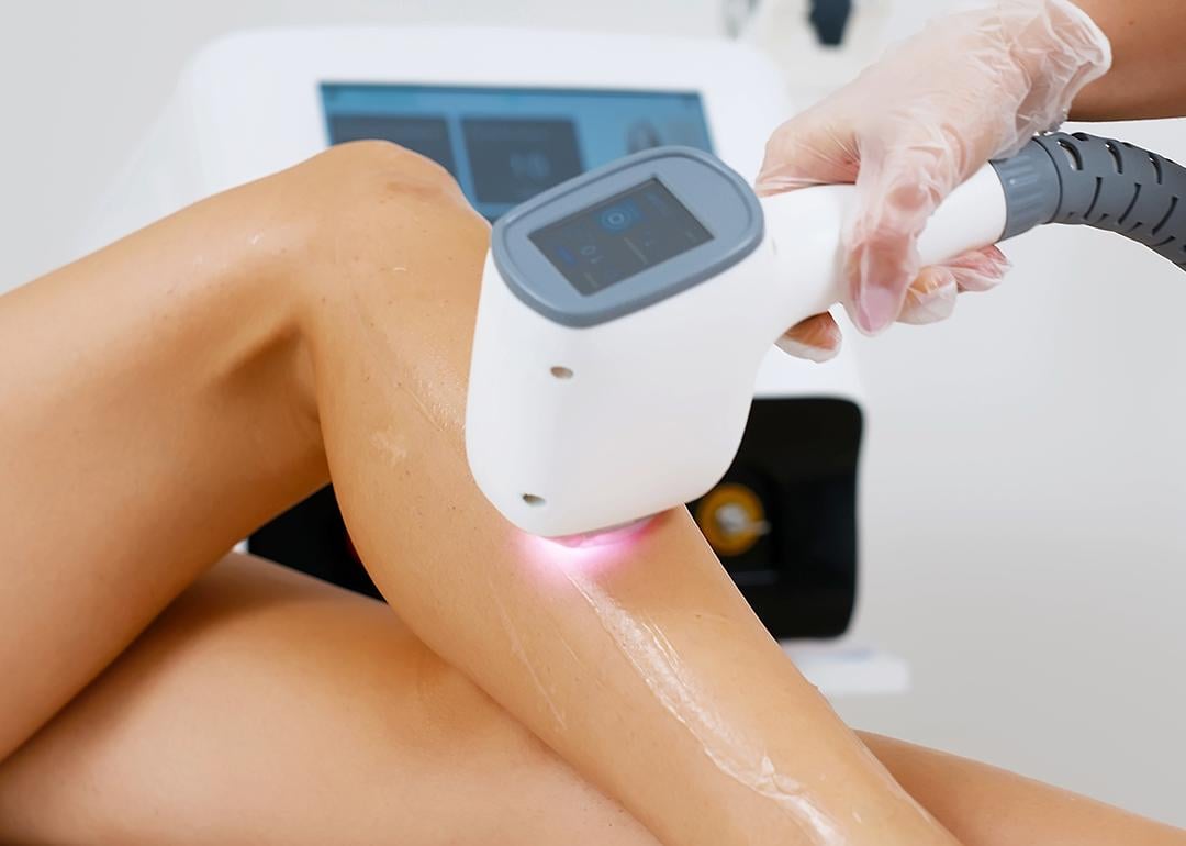 A cosmetologist doing a laser hair removal to a patient in a beauty clinic.