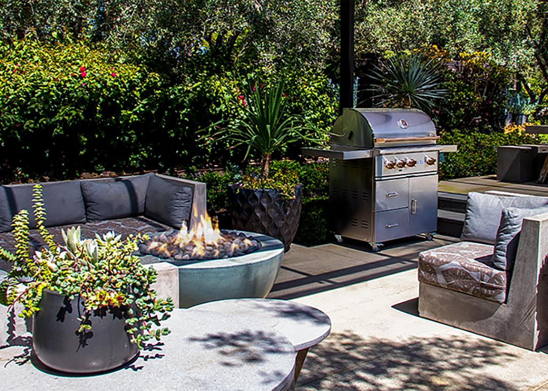 An outdoor entertainment space with gray sofas and a fire pit.