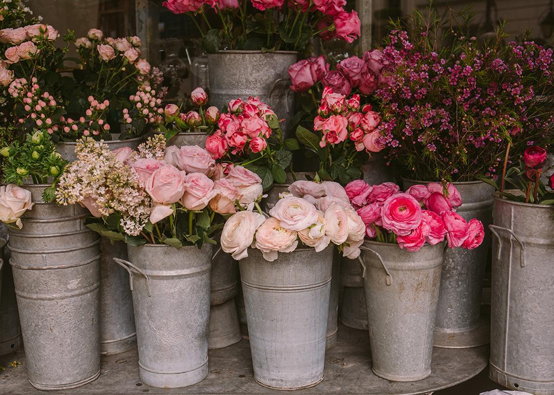Pink roses and other flowers in buckets from a flower shop.
