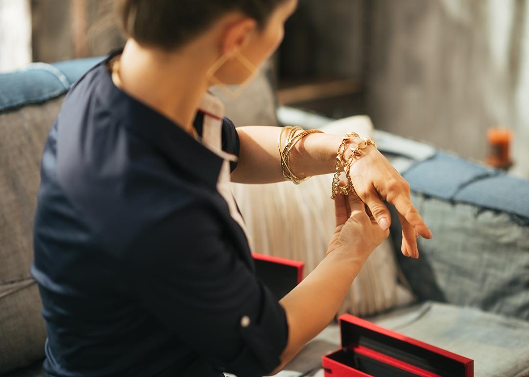 Woman at home trying on jewelry.