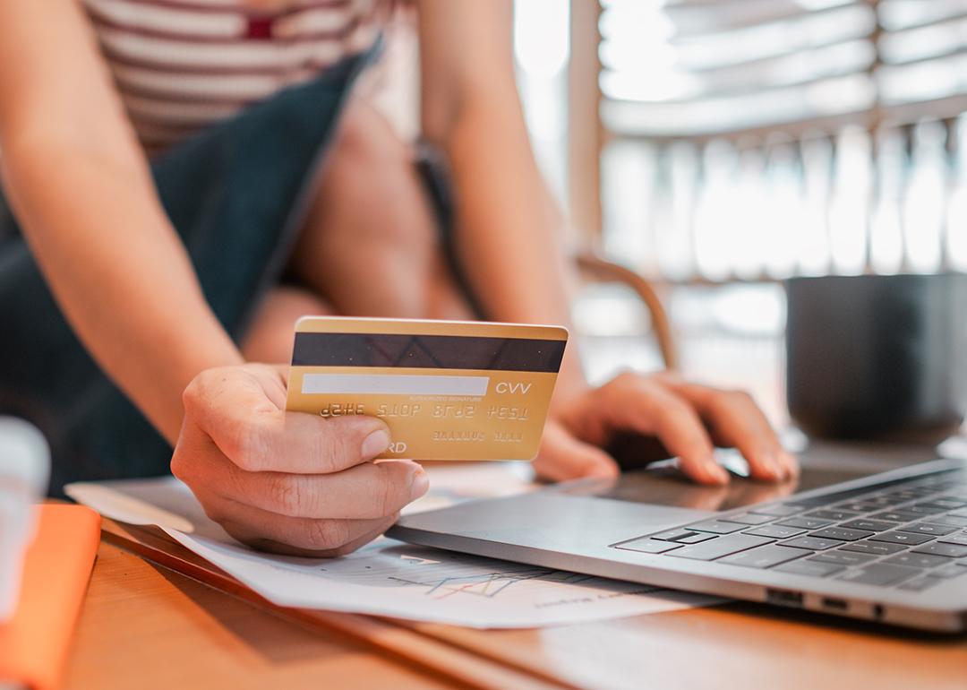 Person holding a credit card to purchase online.