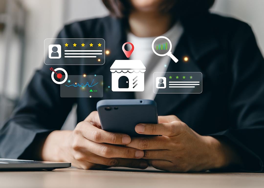 Businesswoman using a phone and illustrated with local SEO insight graphics. 