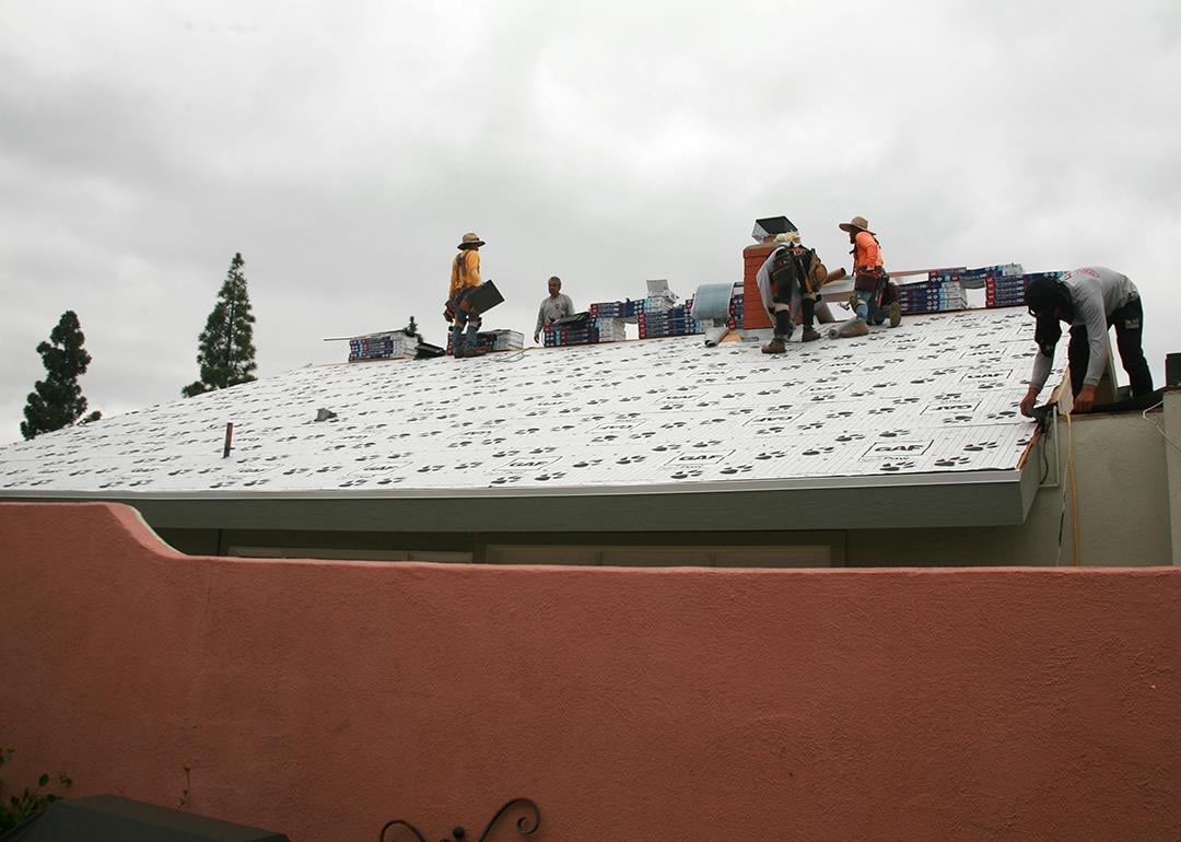 A construction team replacing a home's roof.