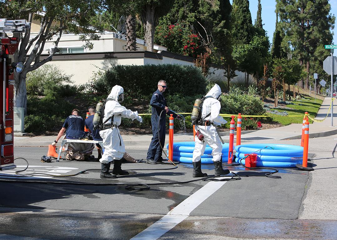 Hazardous materials team cleaning up a truck and chemicals accident on the road.