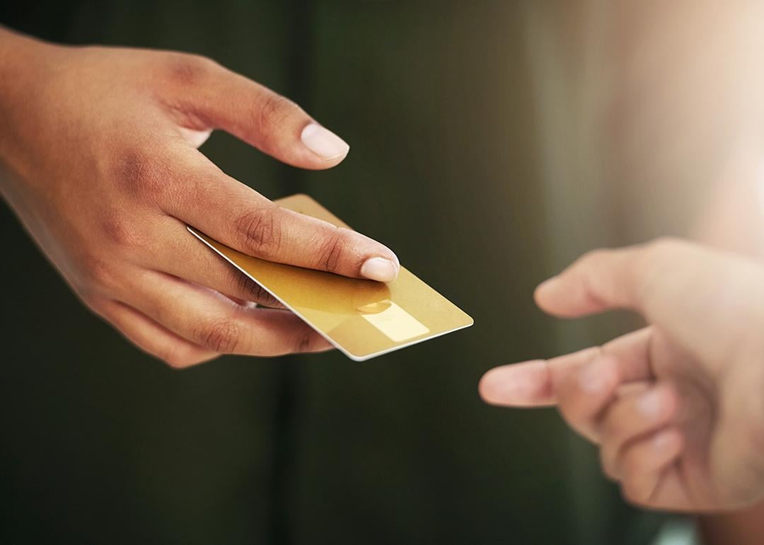 Person handing out a credit card.
