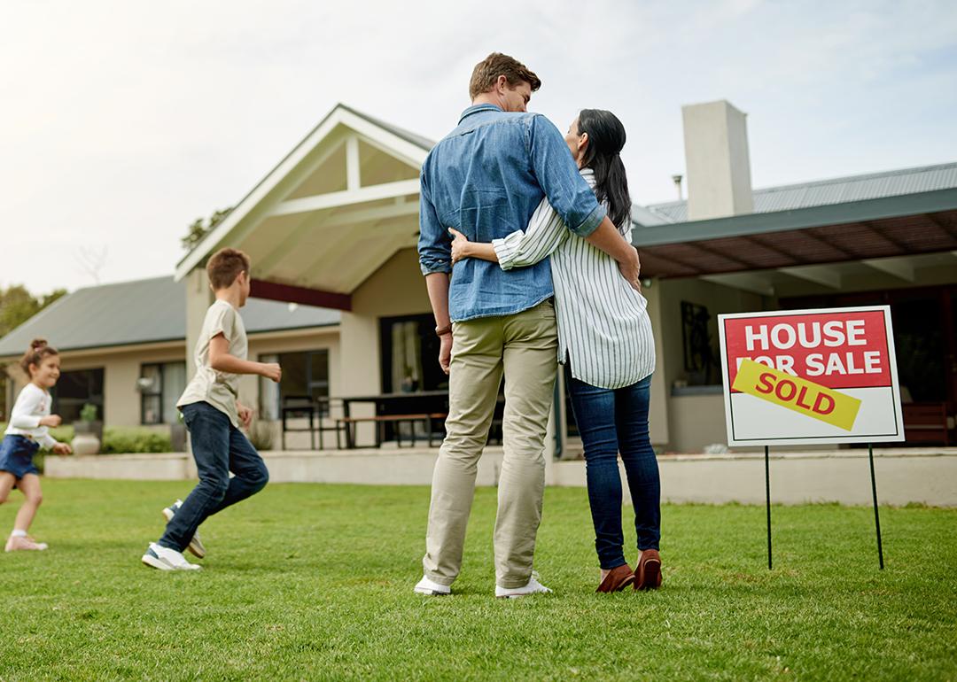 A family of four celebrating on the yard of their new home.