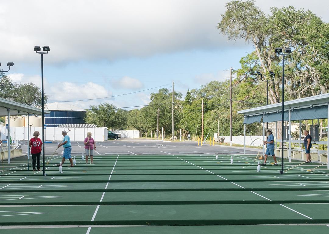 Older people playing shuffleboard at a resort.