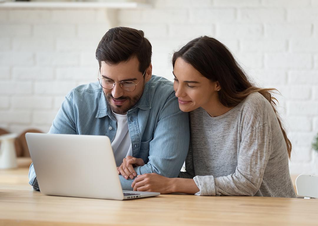 A married couple checking online accounts together in a laptop.