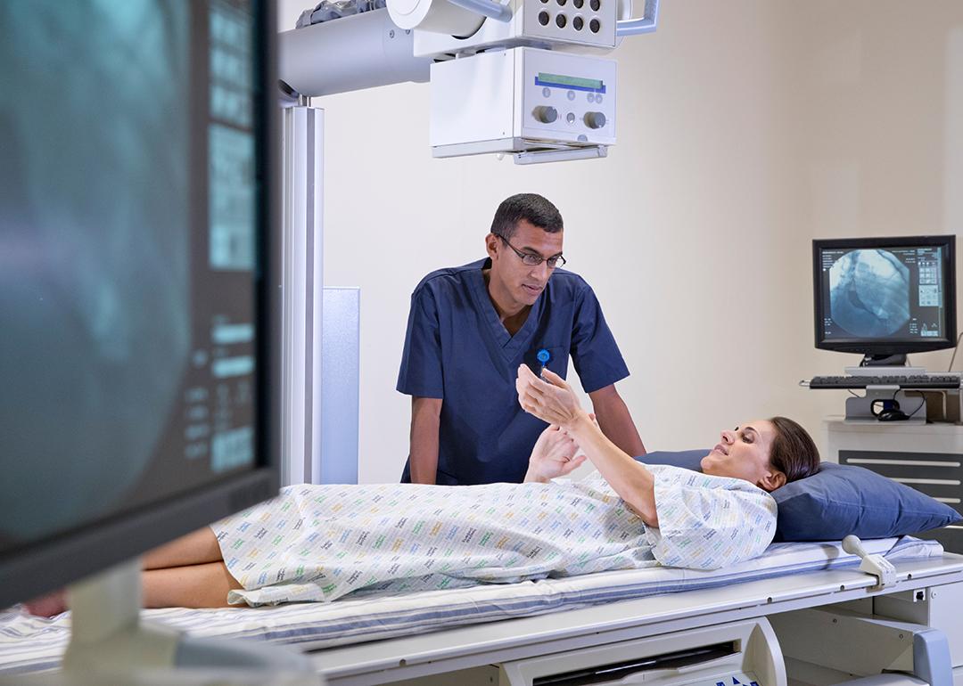 A female X-Ray patient consulting with a radiographer during a screening session.