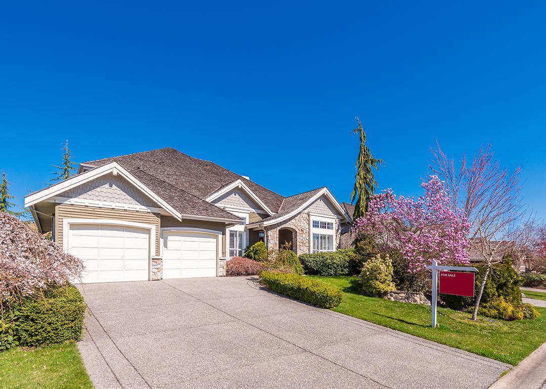 A multi-car garage residential property with a for sale sign.