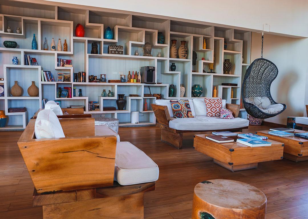 Interior of a luxury modern home's living room showcasing a wide shelf of antiques and books on display.