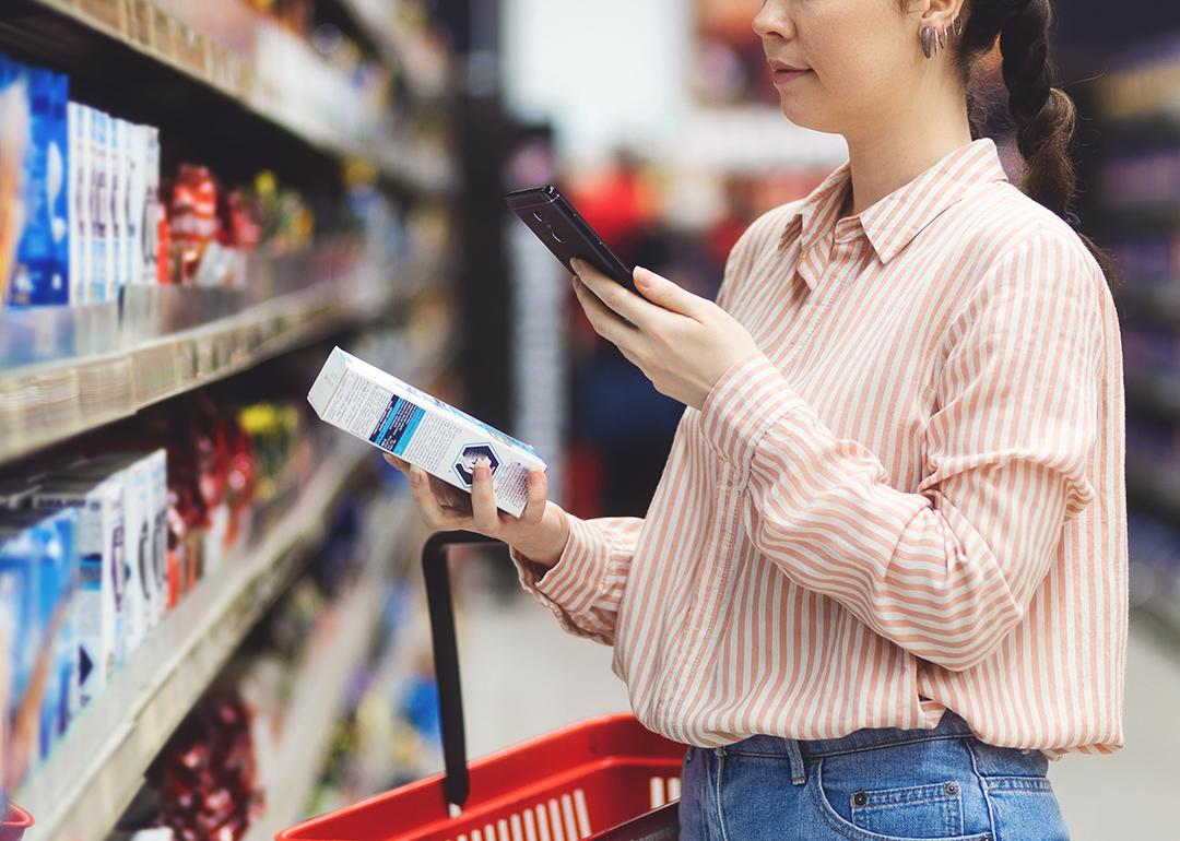 A person scanning a QR code of a product from her smartphone in a supermarket.